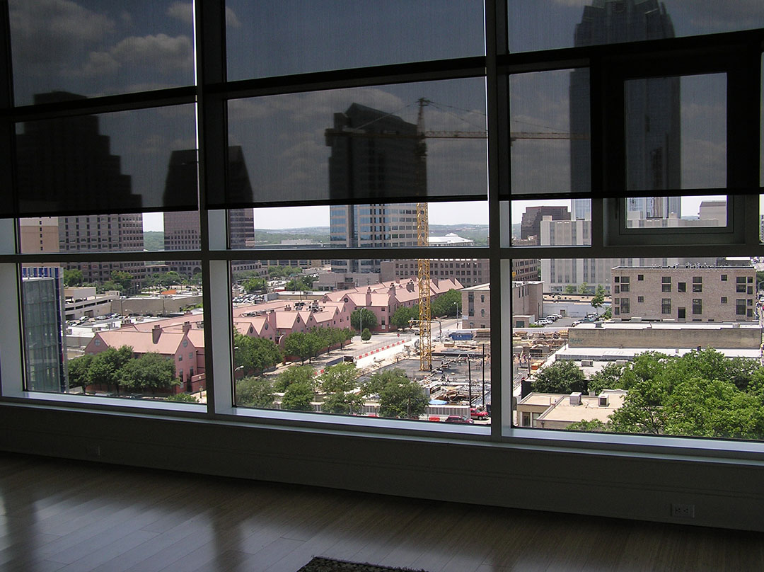 inner shades pulled down lightly overlooking urban setting