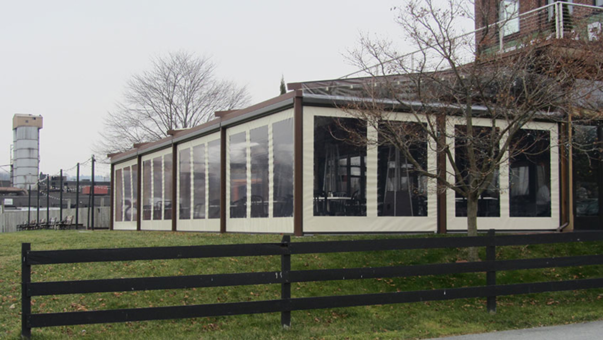 Far away shot of side roller windows on a pergola that is wooden and white