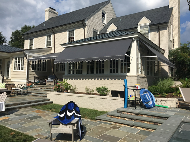 large white house with gray awnings all around