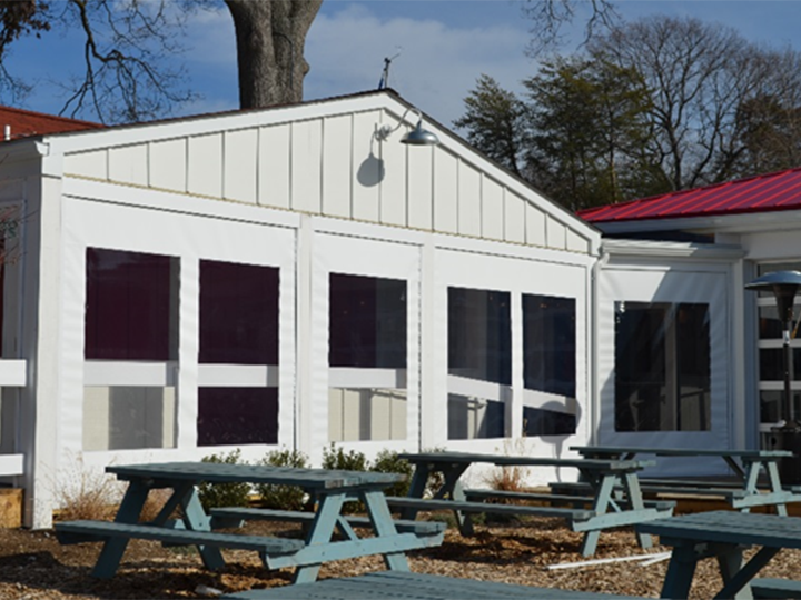 zipper screen with clear vinyl windows and blue picnic tables outside