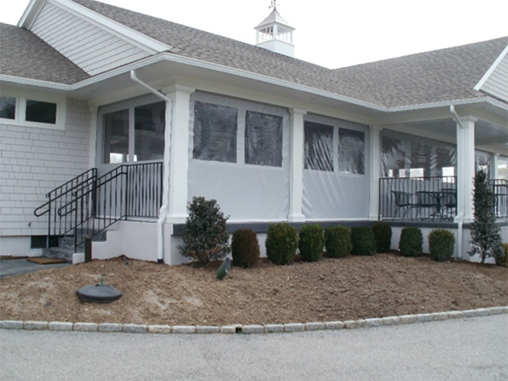 white home with small bushes around front and a screened in porch